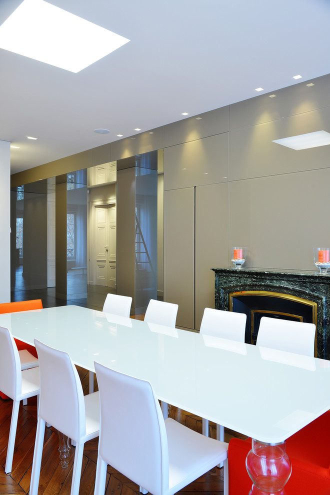 Foto di una sala da pranzo contemporanea con pareti grigie e pavimento in legno massello medio