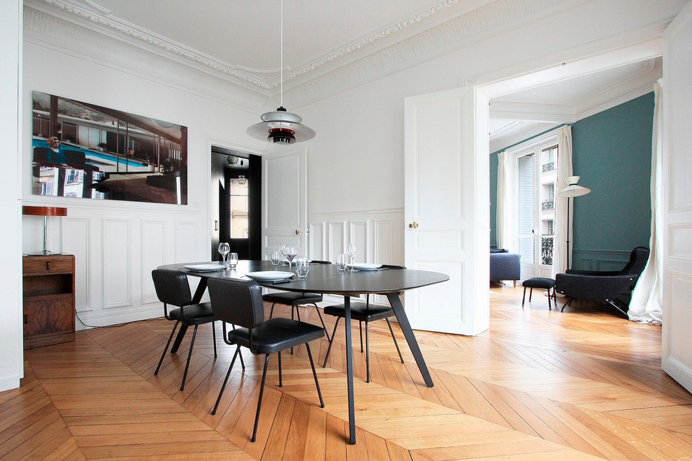 Immagine di una sala da pranzo contemporanea con pareti bianche e parquet chiaro