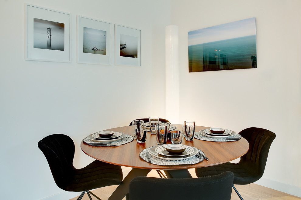 Foto di una sala da pranzo contemporanea chiusa con pareti bianche e parquet chiaro