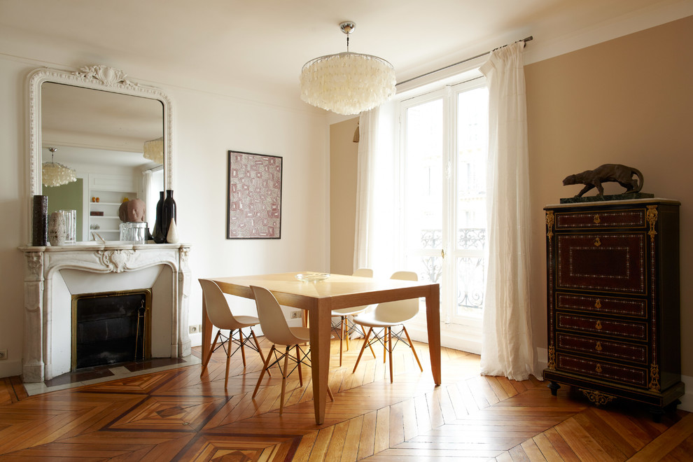 Cette photo montre une salle à manger éclectique de taille moyenne avec un mur blanc, un sol en bois brun, une cheminée standard et un manteau de cheminée en pierre.