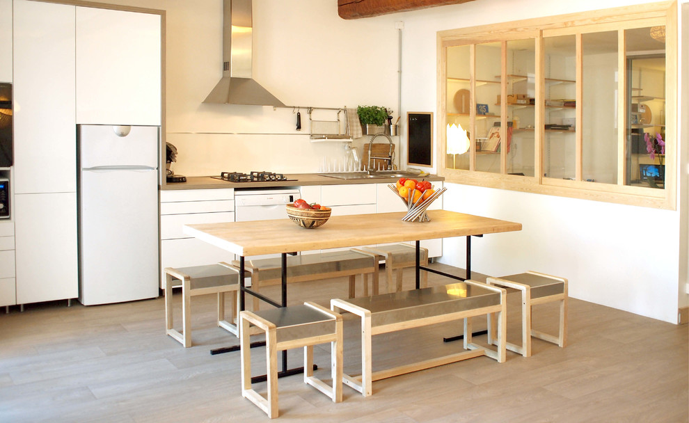 Cette image montre une salle à manger ouverte sur la cuisine nordique de taille moyenne avec un mur blanc, un sol en vinyl et aucune cheminée.