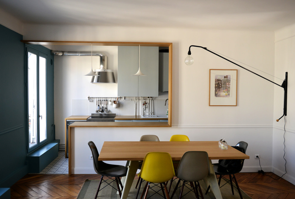 Ispirazione per una sala da pranzo aperta verso la cucina contemporanea di medie dimensioni con pareti bianche e pavimento in legno massello medio
