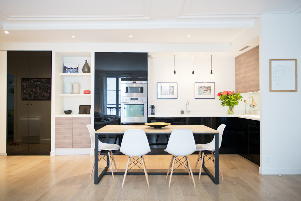 Medium sized contemporary kitchen/dining room in Paris with white walls and medium hardwood flooring.