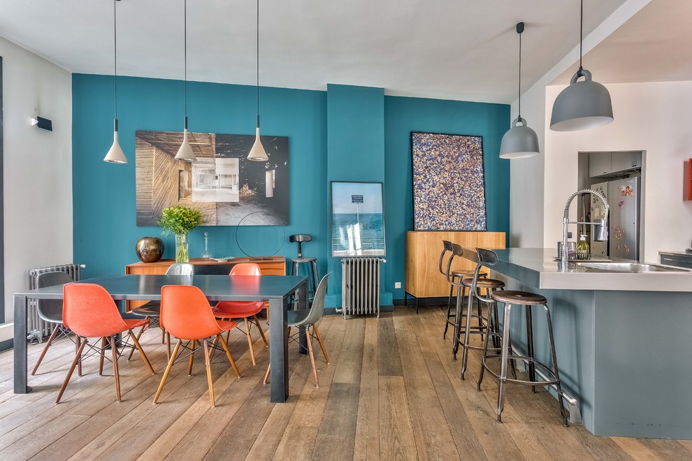 Exemple d'une salle à manger ouverte sur la cuisine chic avec un mur bleu, un sol en bois brun et un sol marron.