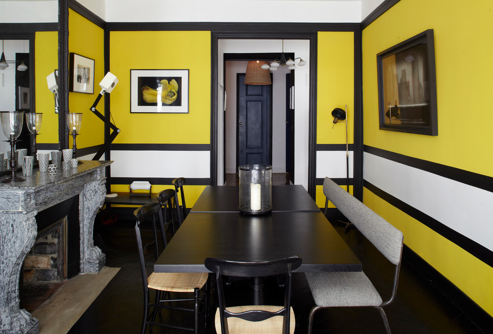 Aménagement d'une salle à manger contemporaine fermée avec un mur multicolore, parquet foncé et une cheminée standard.