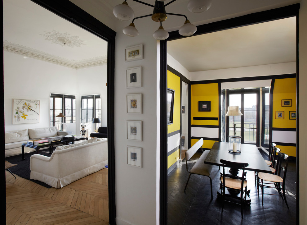 Inspiration pour une salle à manger design fermée et de taille moyenne avec un mur jaune, parquet foncé, aucune cheminée et éclairage.