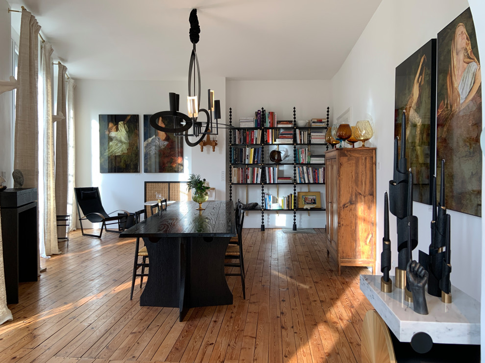 Réalisation d'une grande salle à manger design avec un mur blanc, un sol en bois brun et un sol marron.