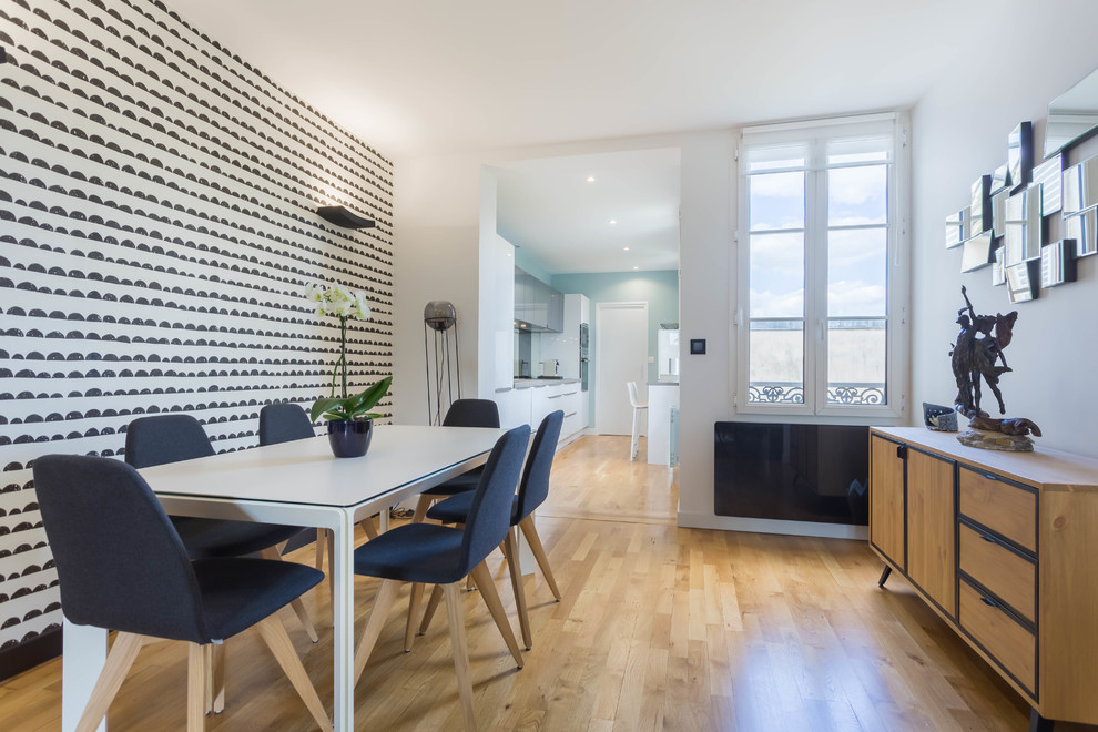 This is an example of a medium sized contemporary open plan dining room in Paris with multi-coloured walls, light hardwood flooring, no fireplace and beige floors.
