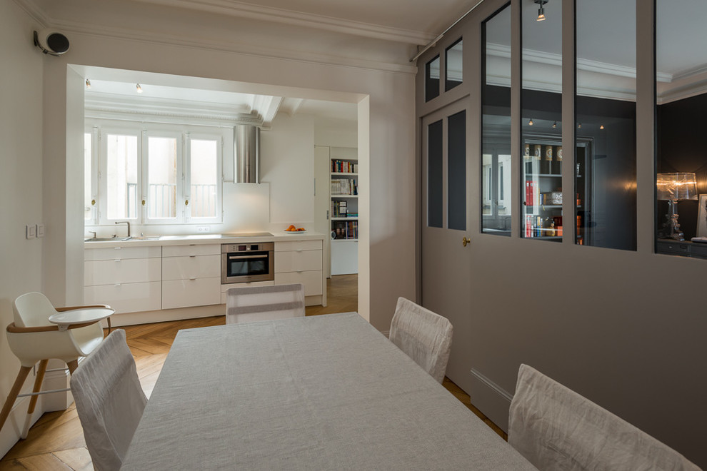 Ispirazione per una sala da pranzo aperta verso il soggiorno contemporanea di medie dimensioni con pareti bianche, pavimento in legno massello medio e pavimento marrone