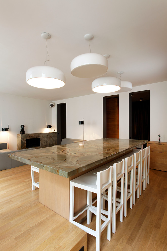 Idee per una grande sala da pranzo aperta verso il soggiorno minimal con pareti bianche e pavimento in legno massello medio