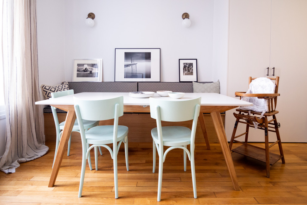 Idées déco pour une salle à manger ouverte sur la cuisine contemporaine de taille moyenne avec parquet clair, un mur blanc et un sol marron.