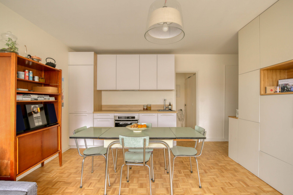 Aménagement d'une salle à manger ouverte sur la cuisine contemporaine avec un mur beige, un sol en bois brun et un sol marron.