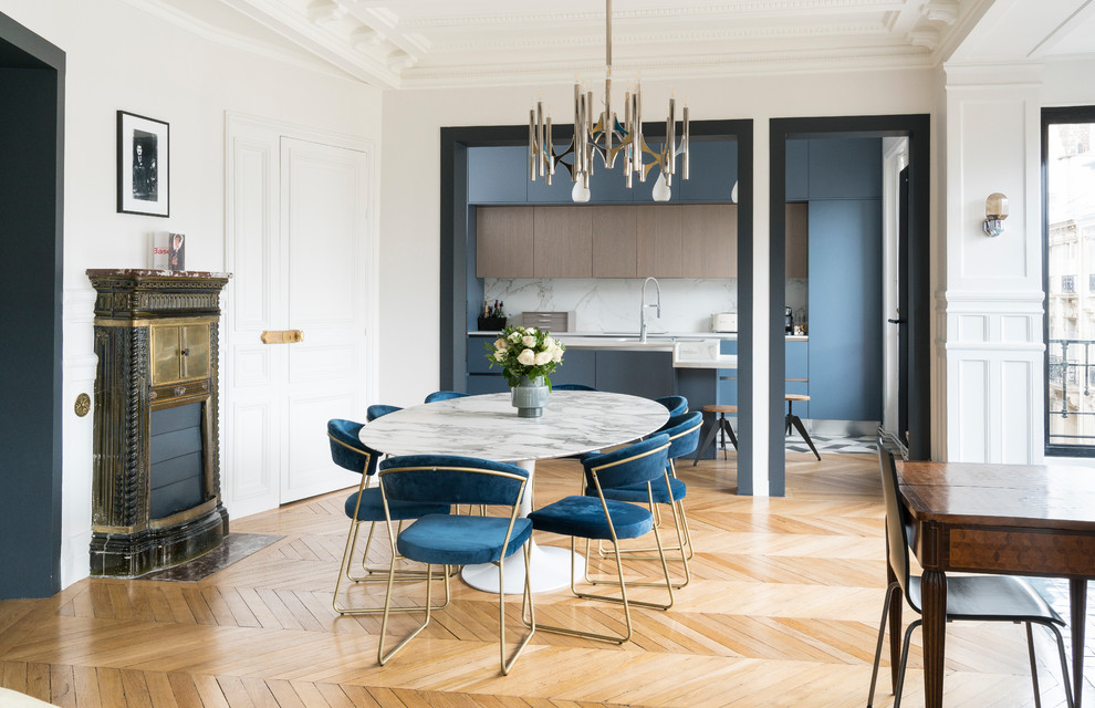 Esempio di una sala da pranzo aperta verso la cucina minimal con pareti bianche, parquet chiaro, stufa a legna e pavimento beige