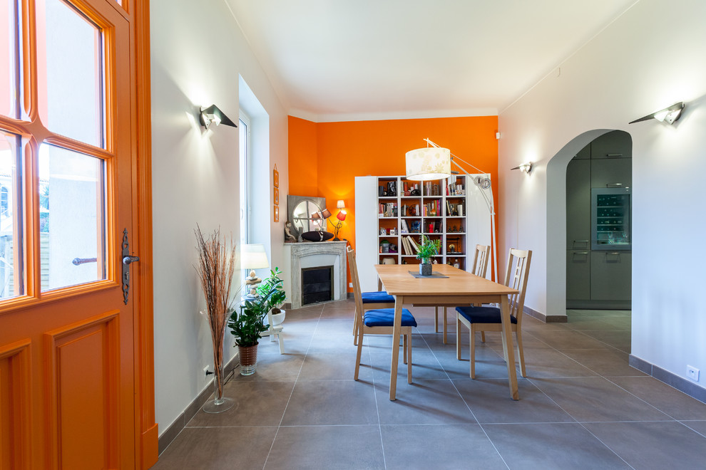 Ispirazione per una sala da pranzo contemporanea chiusa e di medie dimensioni con pareti arancioni e camino ad angolo