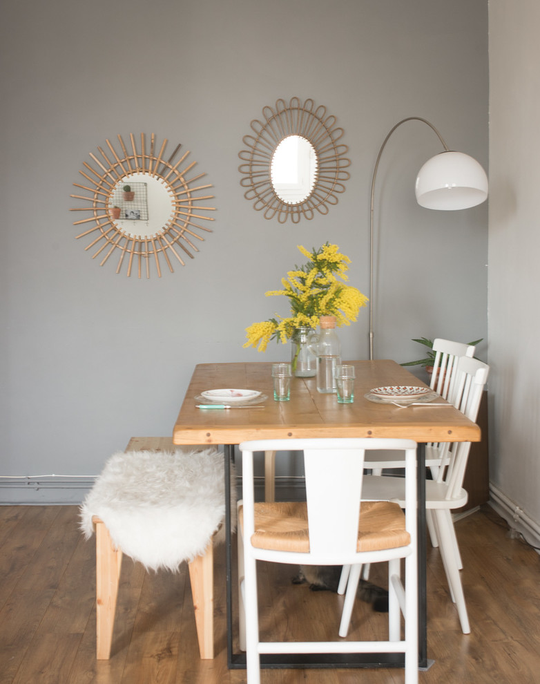Idée de décoration pour une salle à manger ouverte sur le salon bohème de taille moyenne avec un mur gris et un sol en bois brun.