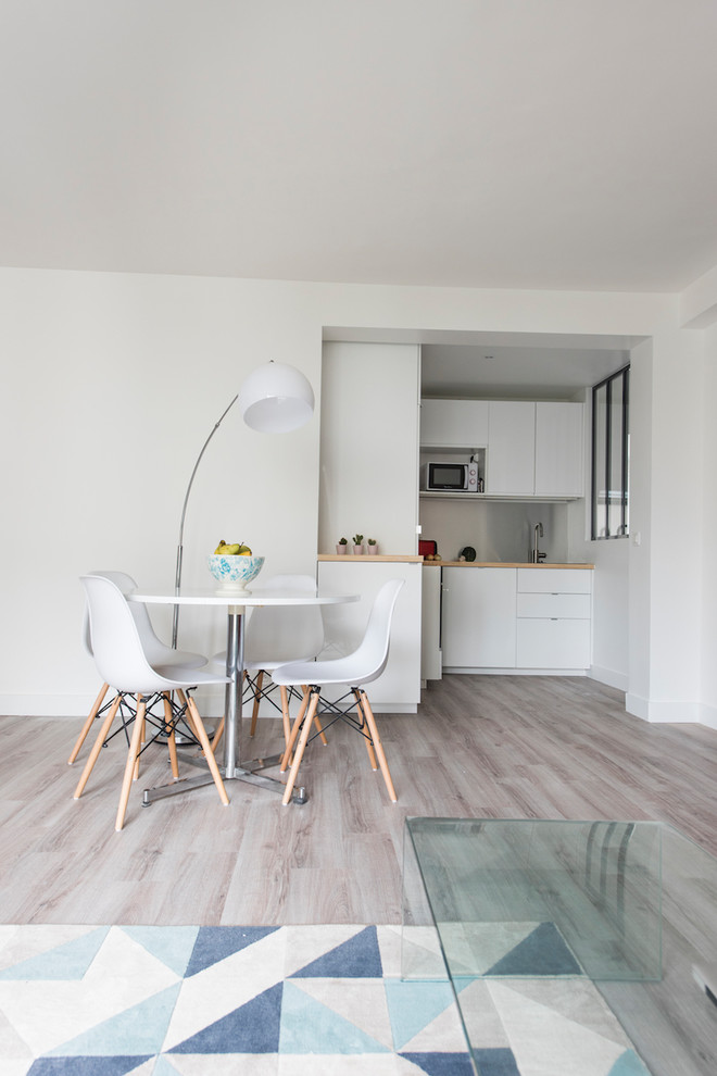 Diseño de comedor contemporáneo grande abierto con paredes blancas, suelo de madera clara y suelo beige