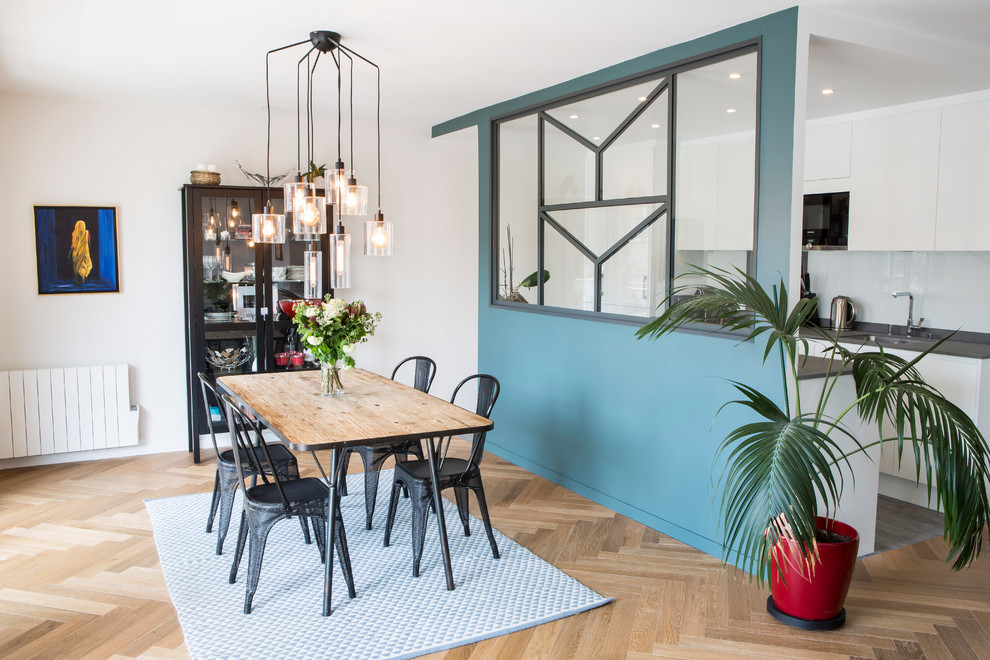 Idées déco pour une grande salle à manger ouverte sur le salon scandinave avec un mur bleu, parquet clair, aucune cheminée et un sol marron.