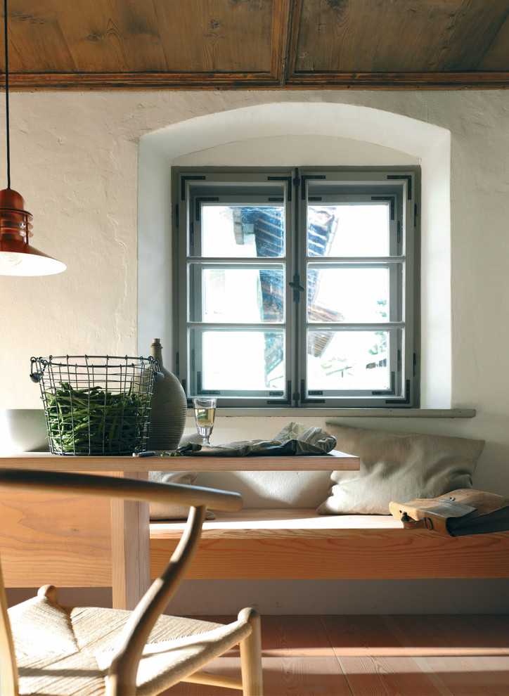 Imagen de comedor actual de tamaño medio abierto con paredes blancas y suelo de madera en tonos medios
