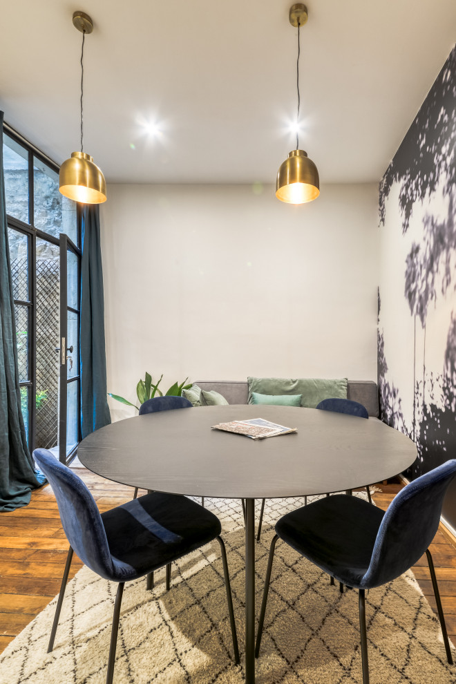 Mittelgroßes Modernes Esszimmer ohne Kamin mit blauer Wandfarbe, braunem Holzboden, braunem Boden und Tapetenwänden in Paris