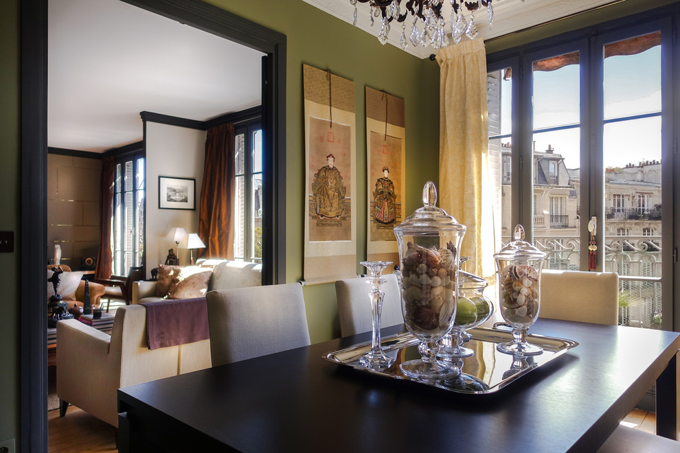 Cette image montre une salle à manger traditionnelle avec parquet clair et un mur vert.