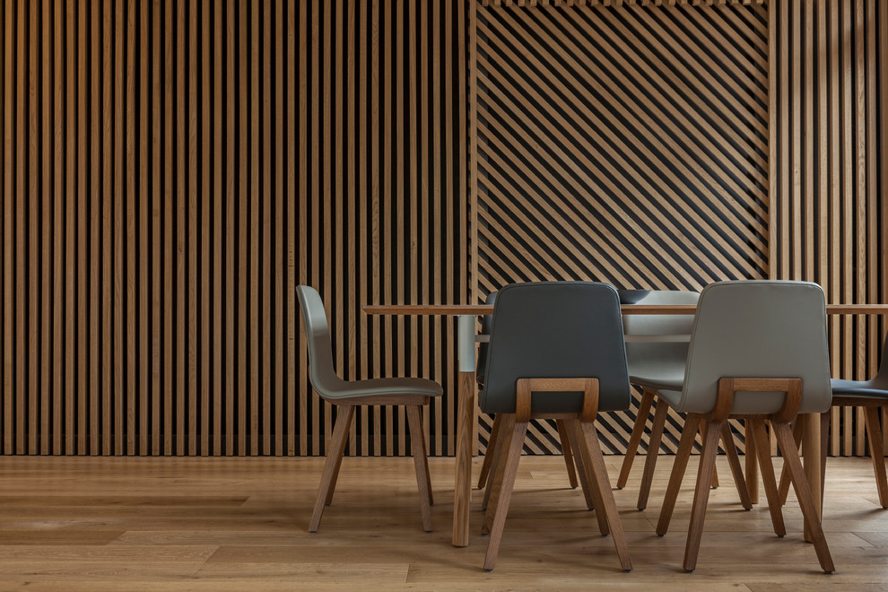 Cette photo montre une salle à manger ouverte sur le salon tendance de taille moyenne avec un mur marron, parquet clair et aucune cheminée.