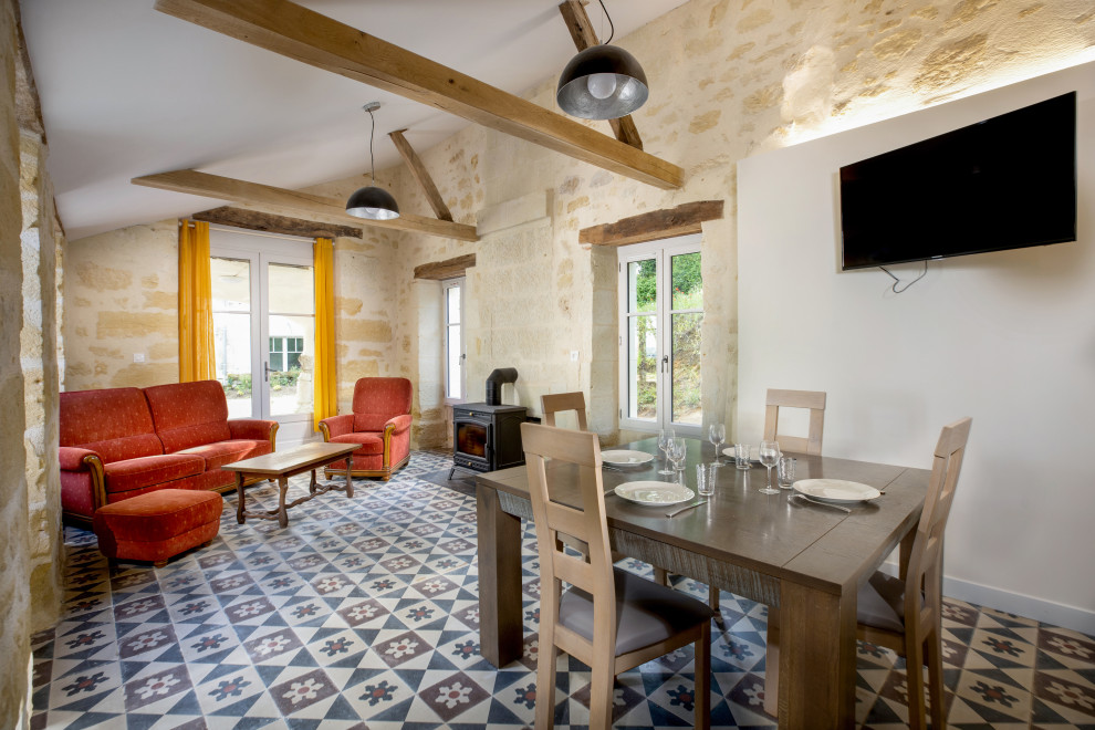 Inspiration pour une salle à manger ouverte sur le salon rustique avec un mur blanc, un sol multicolore et un plafond voûté.