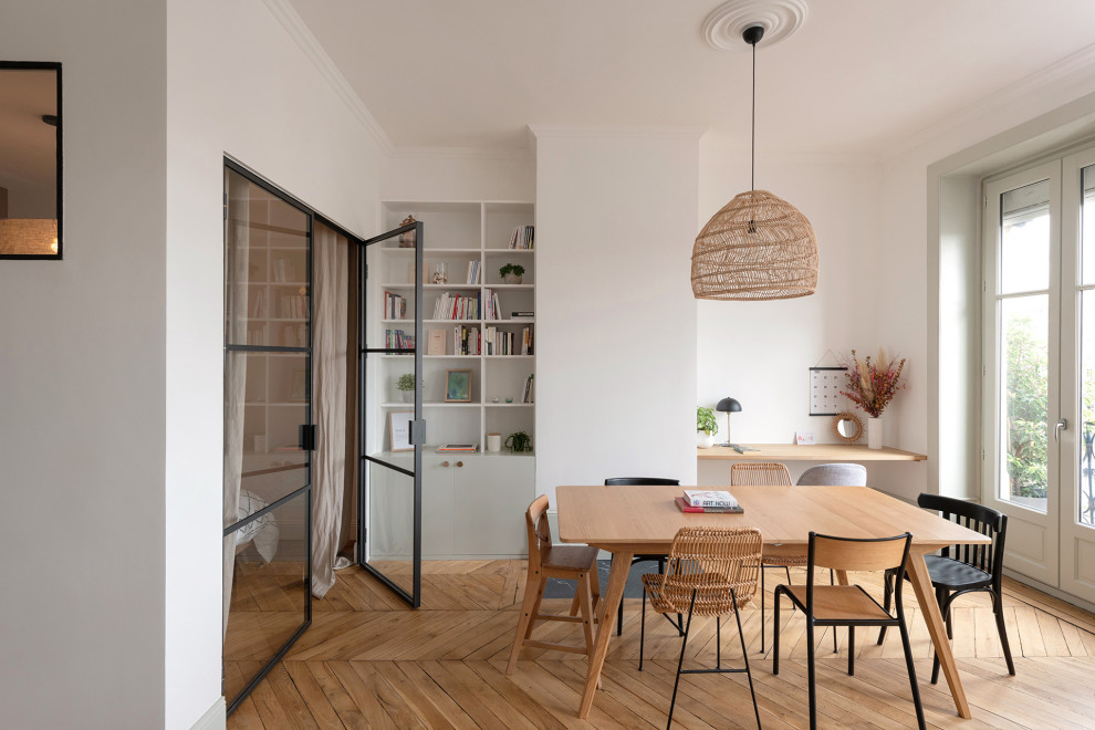 Idée de décoration pour une salle à manger nordique avec un mur blanc, un sol en bois brun et un sol marron.