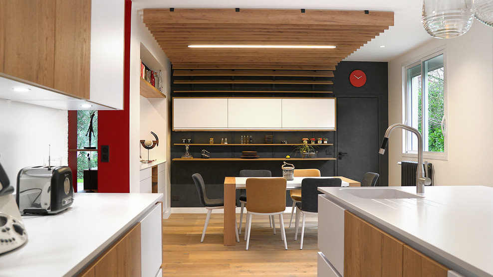 Idéer för en stor modern matplats med öppen planlösning, med svarta väggar, ljust trägolv och grått golv