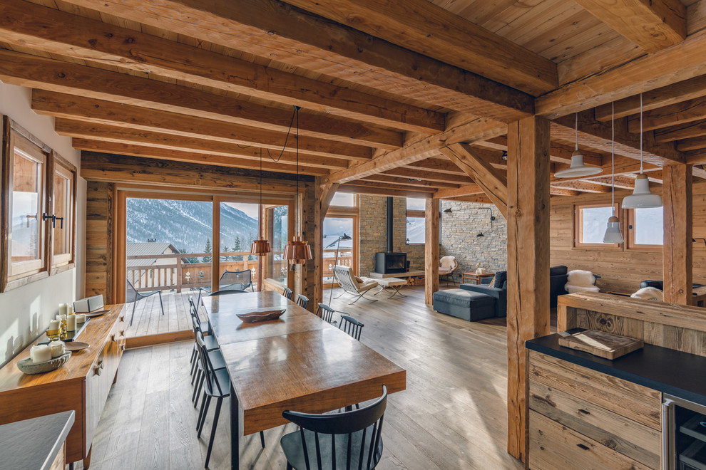 Immagine di una grande sala da pranzo aperta verso il soggiorno rustica con pareti bianche e parquet chiaro