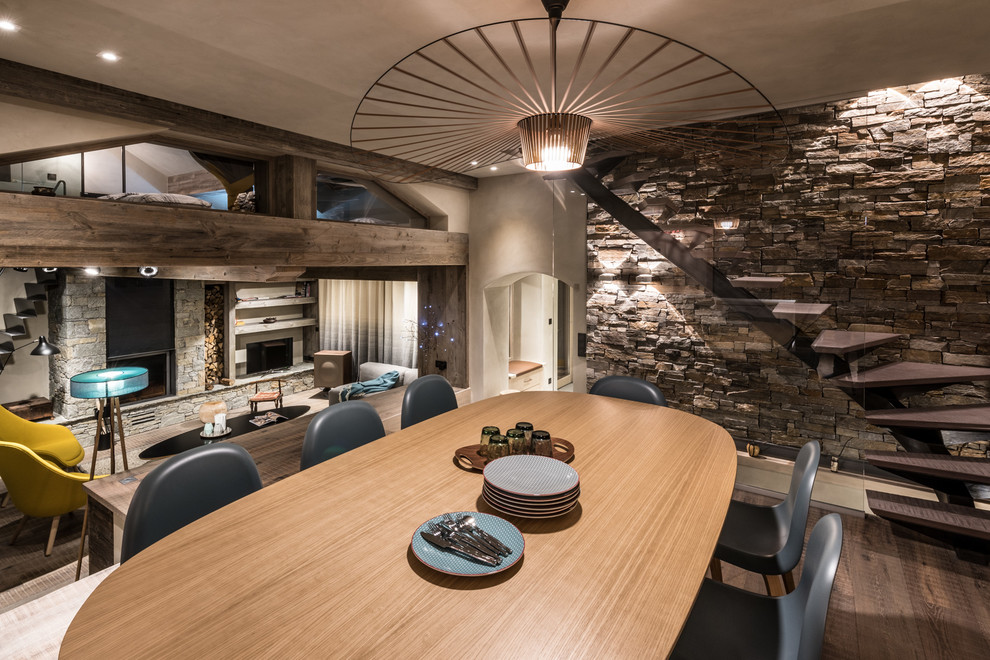 Immagine di una grande sala da pranzo aperta verso il soggiorno stile rurale con pavimento in legno massello medio
