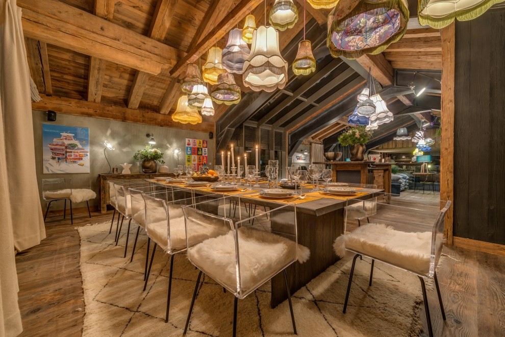 Immagine di una grande sala da pranzo aperta verso il soggiorno stile rurale con pareti grigie, pavimento in legno massello medio e nessun camino