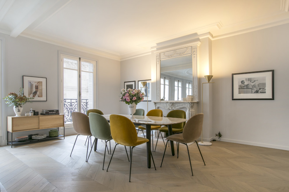 Diseño de comedor nórdico con paredes grises, suelo de madera clara, todas las chimeneas y suelo beige