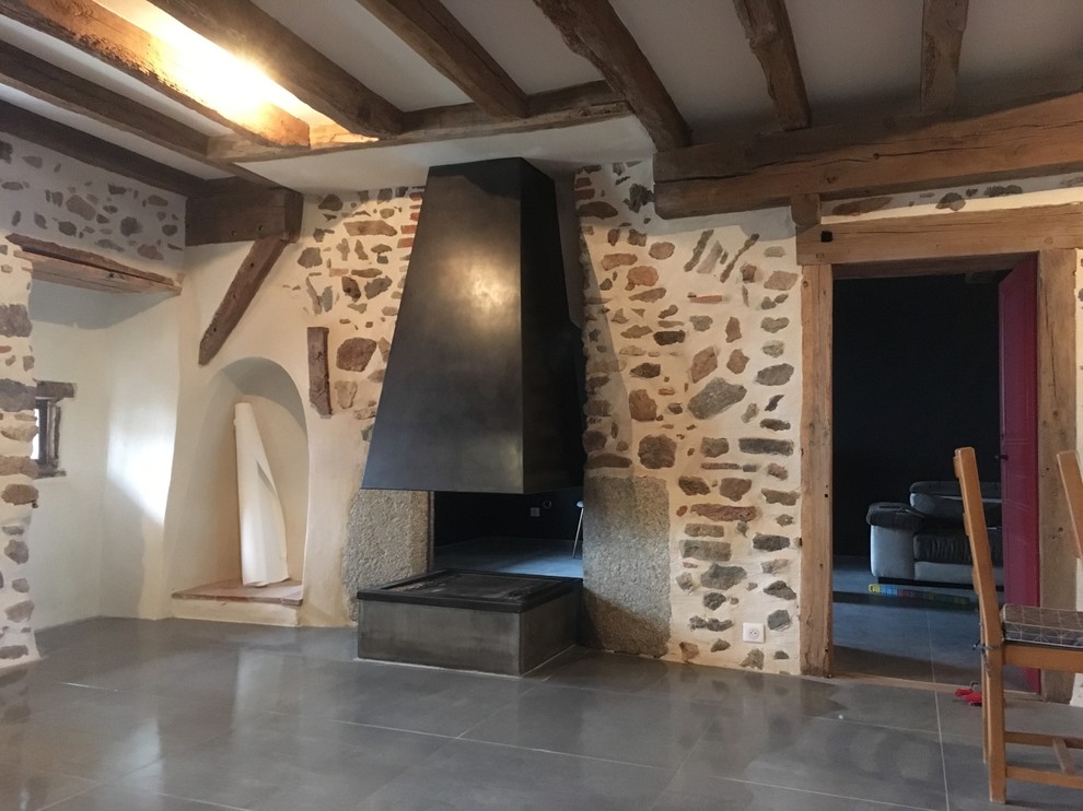 Cette image montre une salle à manger rustique de taille moyenne avec cheminée suspendue et un manteau de cheminée en métal.