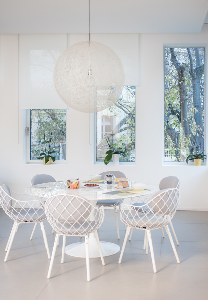 Foto di una sala da pranzo aperta verso il soggiorno stile marinaro di medie dimensioni con pareti bianche e pavimento in cemento