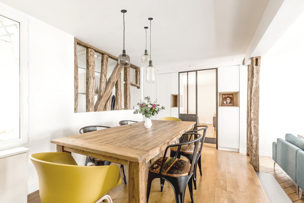 Idee per una sala da pranzo aperta verso il soggiorno scandinava di medie dimensioni con pareti bianche, nessun camino, pavimento in legno massello medio e pavimento marrone