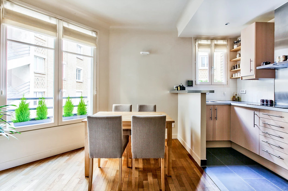 Cette image montre une salle à manger ouverte sur la cuisine traditionnelle de taille moyenne avec un mur beige, parquet clair et un sol marron.