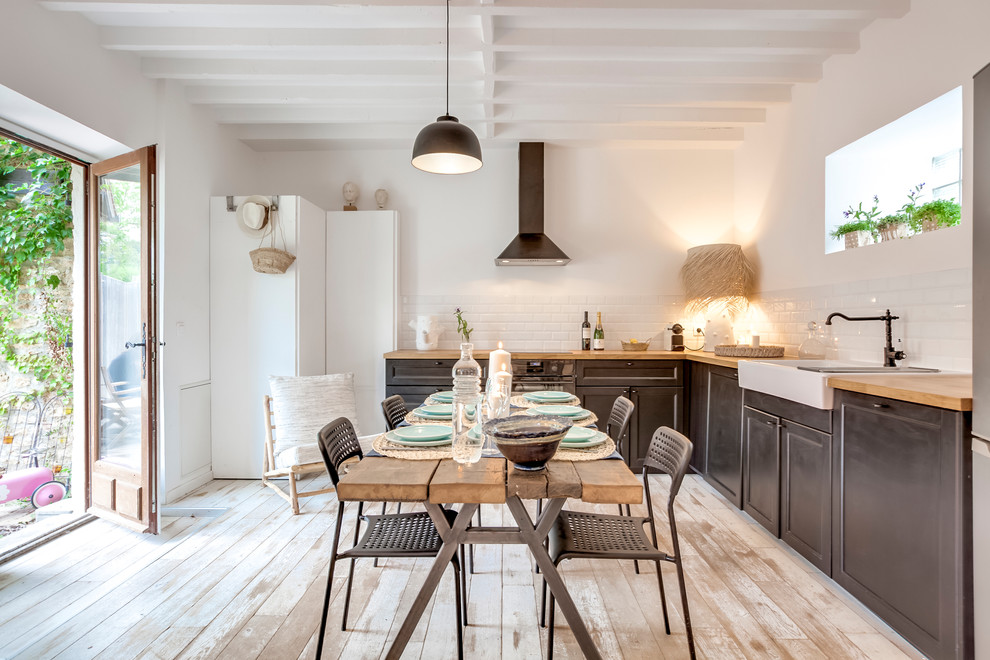Inspiration pour une salle à manger ouverte sur la cuisine traditionnelle avec un mur blanc, parquet clair, un sol beige et éclairage.