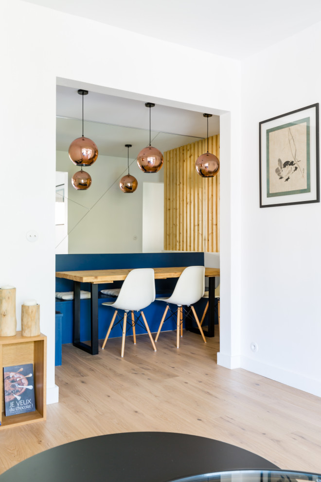Exemple d'une salle à manger tendance avec un mur bleu, parquet clair et un sol beige.
