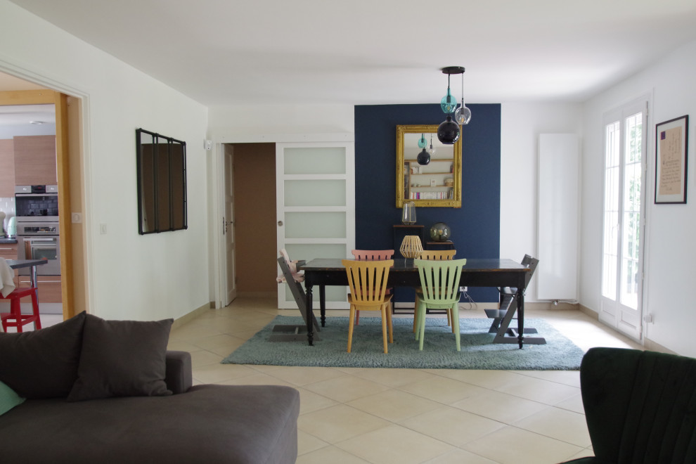 Exemple d'une salle à manger ouverte sur le salon tendance de taille moyenne avec un mur bleu, un sol en carrelage de céramique et un sol beige.