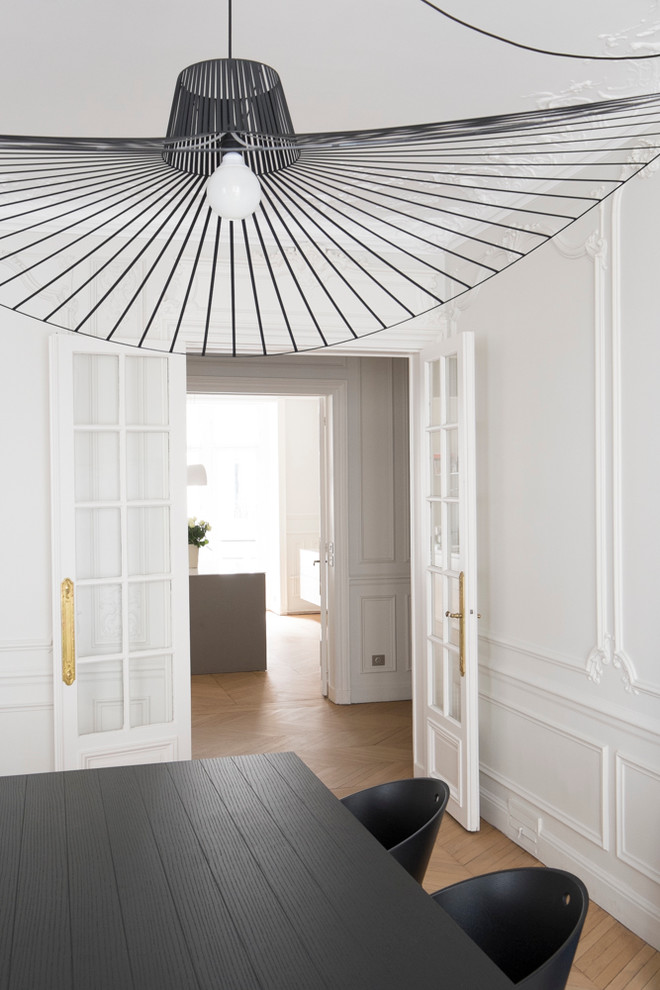Geschlossenes, Mittelgroßes Modernes Esszimmer mit weißer Wandfarbe und braunem Holzboden in Paris