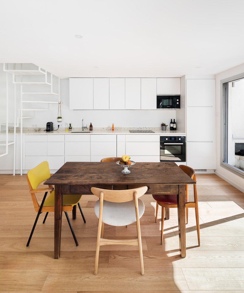 Idée de décoration pour une salle à manger ouverte sur le salon design avec un mur blanc, aucune cheminée, un sol marron et parquet clair.