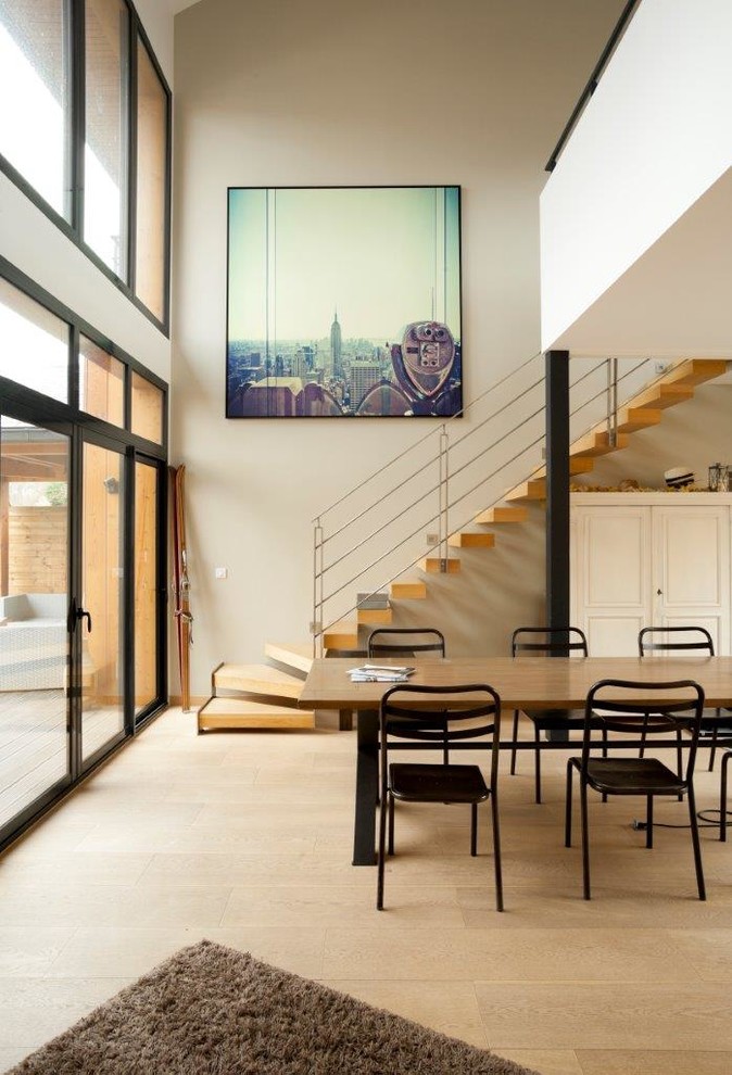 Foto di una grande sala da pranzo aperta verso il soggiorno minimal con pareti beige, parquet chiaro e nessun camino