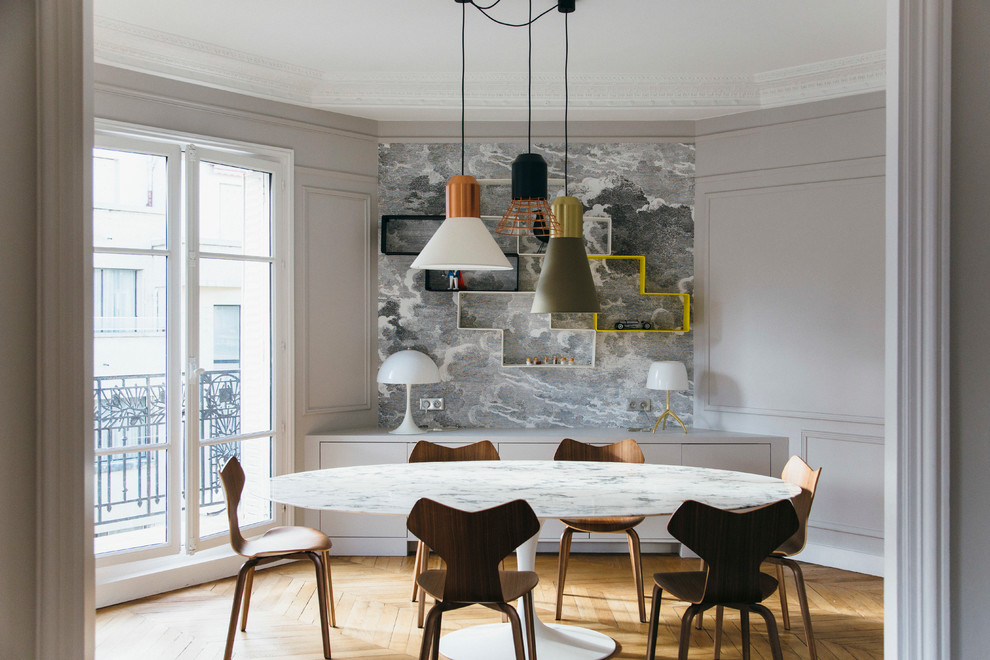 Medium sized contemporary enclosed dining room in Paris with grey walls, medium hardwood flooring and feature lighting.