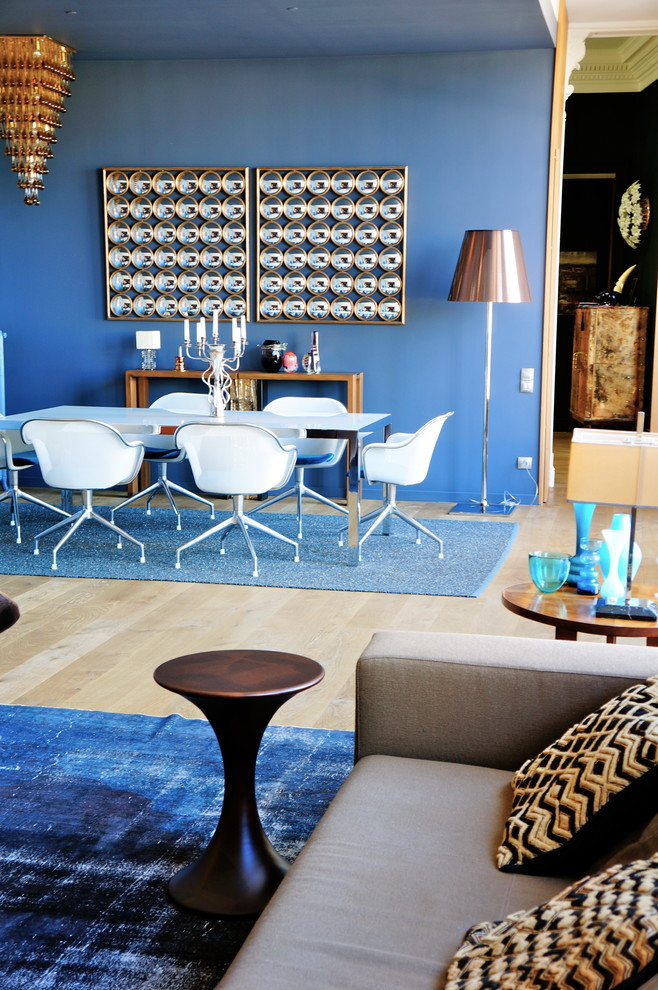 Exemple d'une salle à manger ouverte sur le salon tendance de taille moyenne avec un mur bleu et parquet clair.