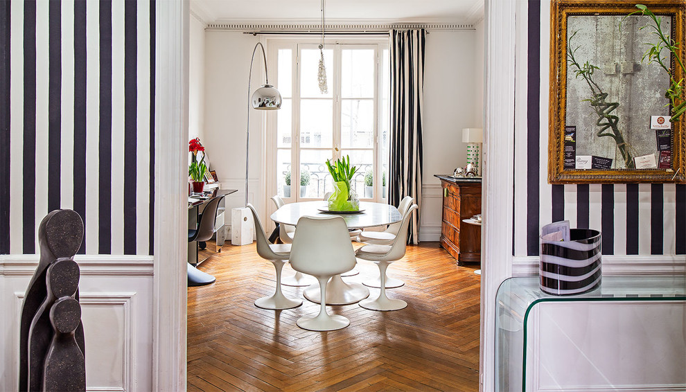 Modernes Esszimmer mit braunem Holzboden und weißer Wandfarbe in Paris