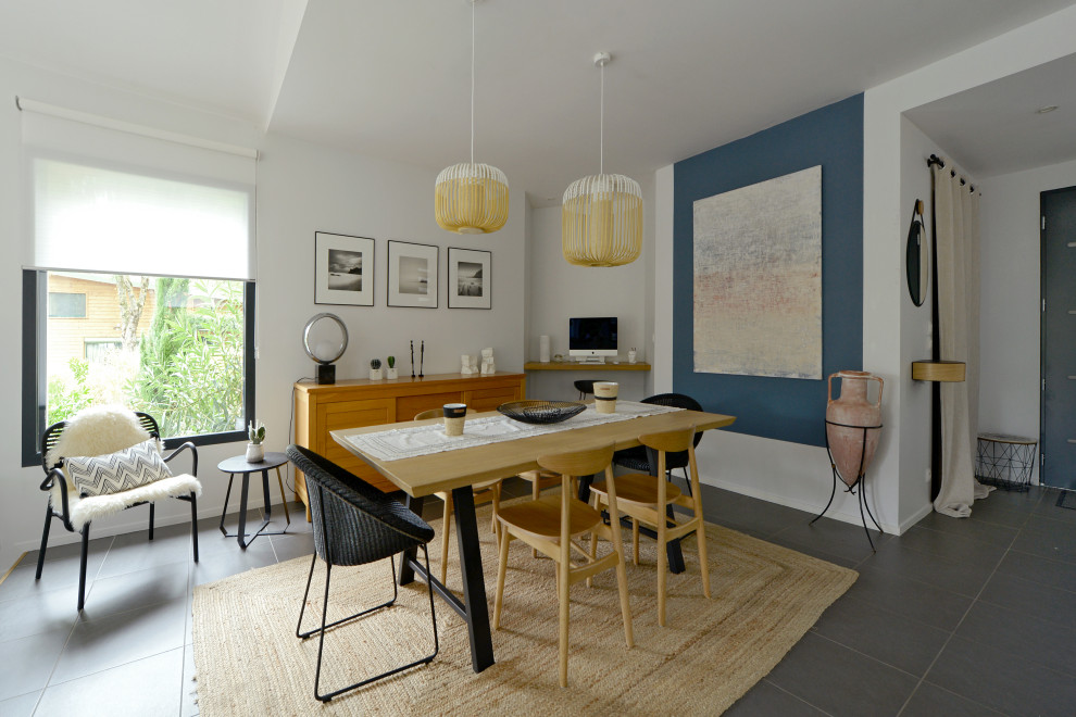 Réalisation d'une salle à manger design de taille moyenne avec un mur blanc et un sol gris.