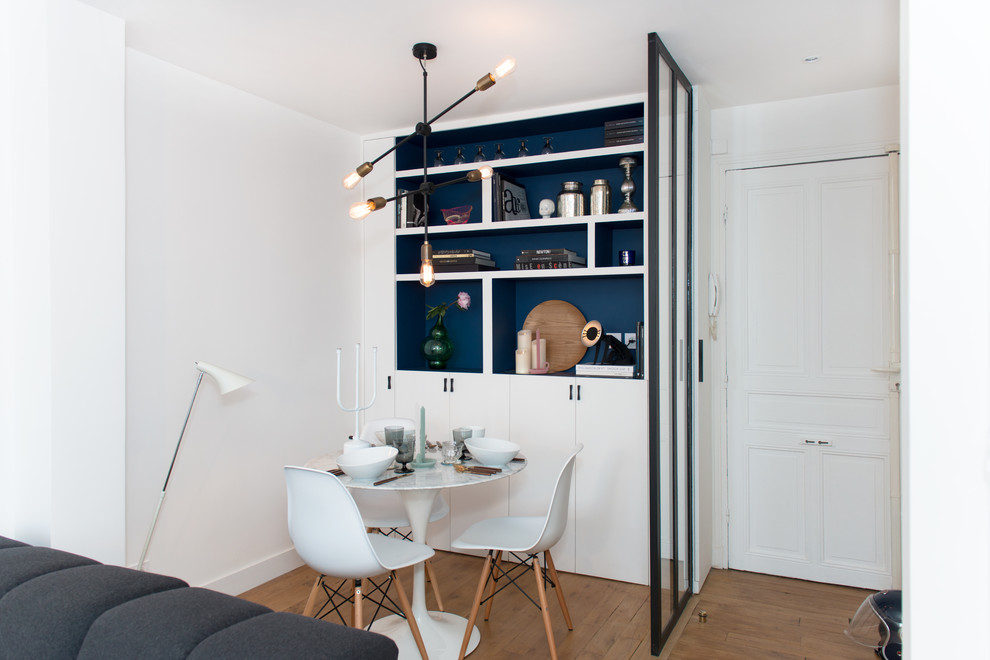 Offenes, Kleines Modernes Esszimmer ohne Kamin mit weißer Wandfarbe und braunem Holzboden in Paris