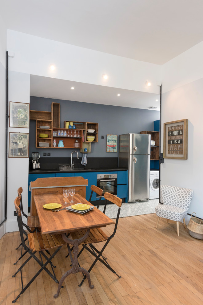 Immagine di una sala da pranzo aperta verso il soggiorno moderna di medie dimensioni con pareti grigie e parquet chiaro