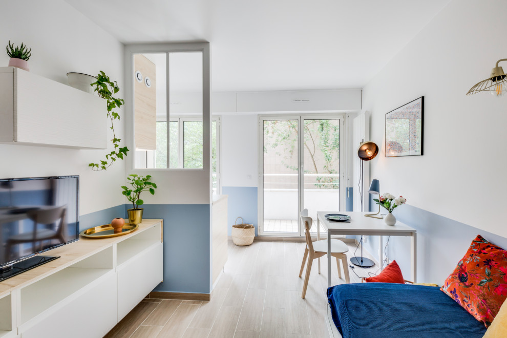 Foto de comedor pequeño con paredes azules y suelo de madera clara