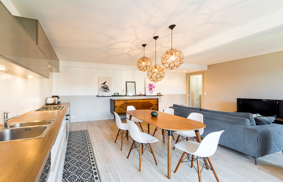 Exemple d'une salle à manger ouverte sur le salon tendance avec un mur blanc, parquet clair, aucune cheminée et un sol beige.